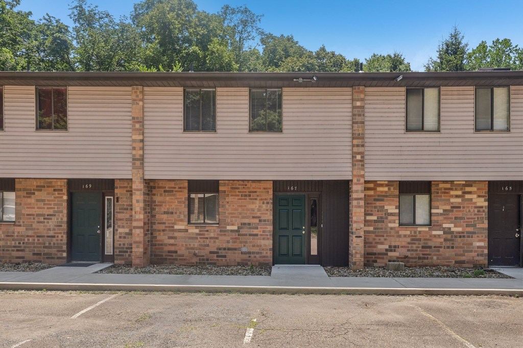 A building with brick walls and a green door.
