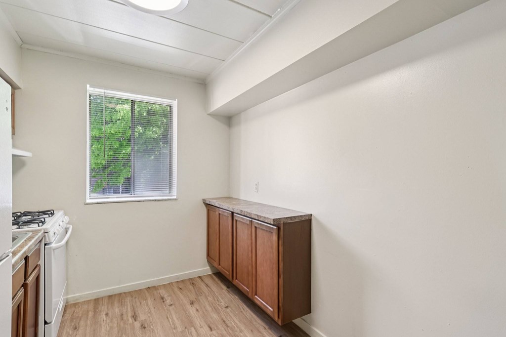 A kitchen with a washing machine and a window.