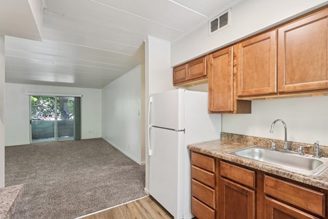 A kitchen with a white fridge and wooden cabinets.