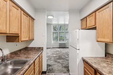 A kitchen with wooden cabinets and a white refrigerator.