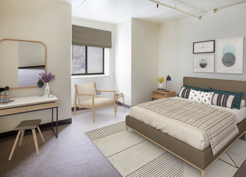A bedroom with a bed, chair, and vanity table.