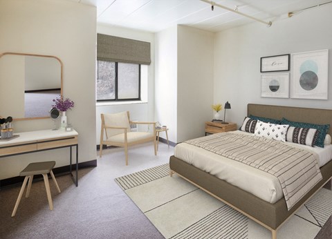 A bedroom with a bed, chair, and vanity table.