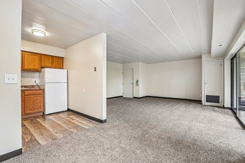 A kitchen with a white refrigerator and wooden cabinets.