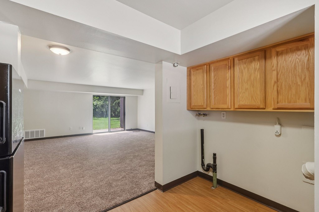 A room with wooden cabinets and a carpeted floor.