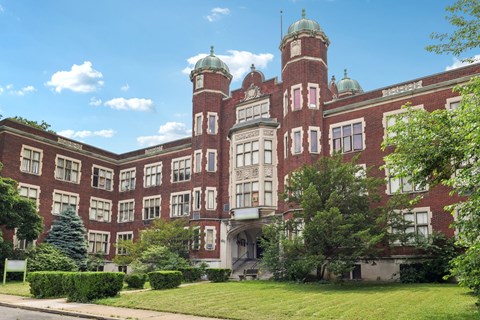 A large red brick building with a green dome on top.