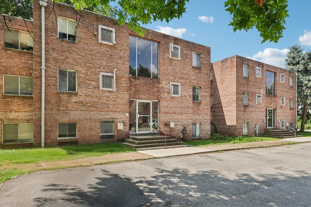 A red brick building with a green lawn in front.