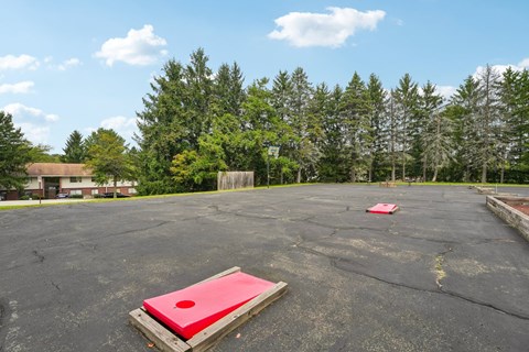 A red square object is placed on a wooden pallet in a parking lot.