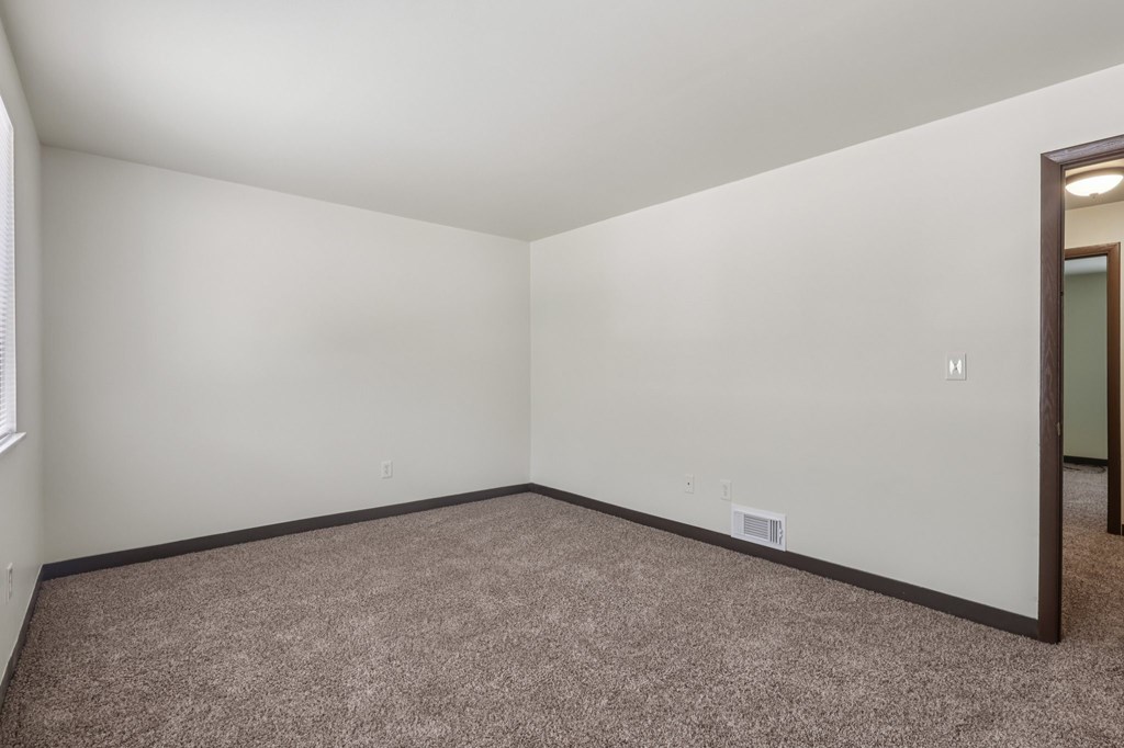 A room with a carpeted floor and white walls.