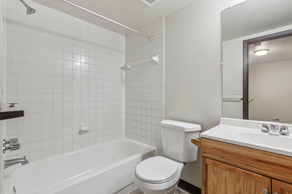 A white toilet sits next to a white sink in a bathroom.