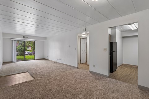 A spacious room with a carpeted floor and a slanted ceiling.