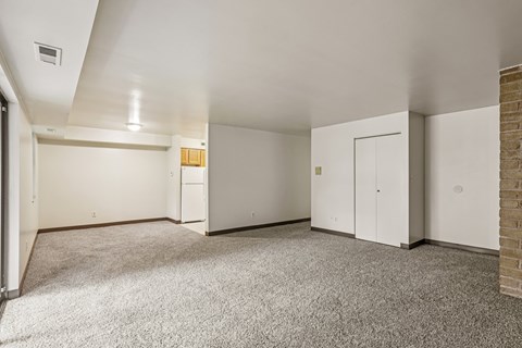 A spacious room with a carpeted floor and white walls.