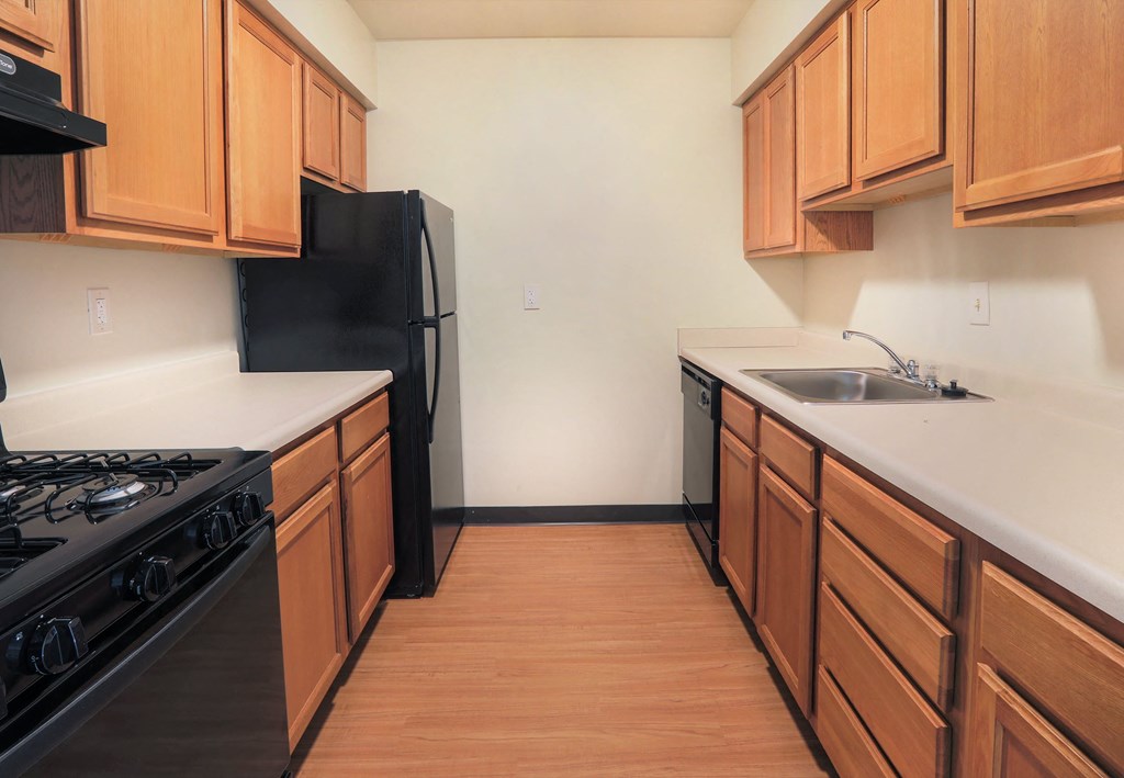 A kitchen with wooden cabinets and black appliances.