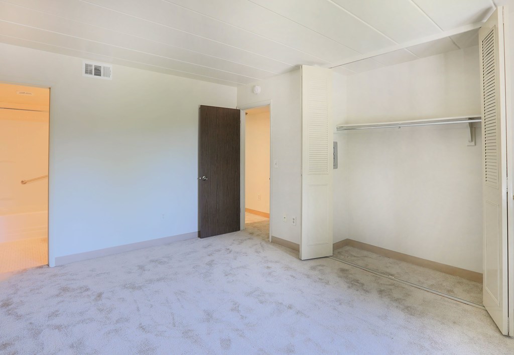 A room with a door, a shelf, and a wall socket.