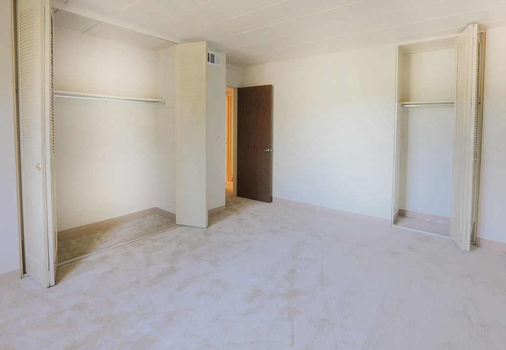 A room with a brown door and white walls.