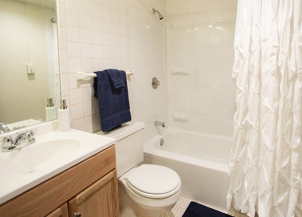 A white bathroom with a toilet, sink, and bathtub.