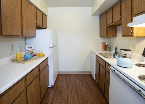 A kitchen with wooden cabinets and white appliances.