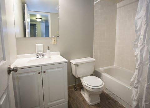 A white bathroom with a toilet, sink, and bathtub.