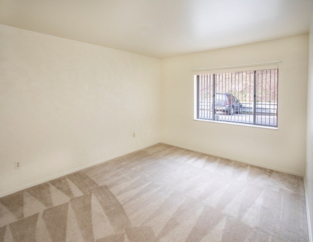 A room with a window and a car outside.