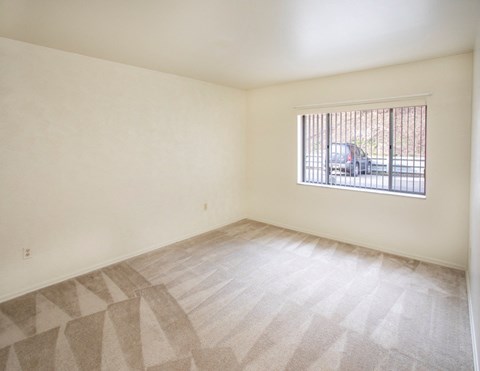 A room with a window and a car outside.