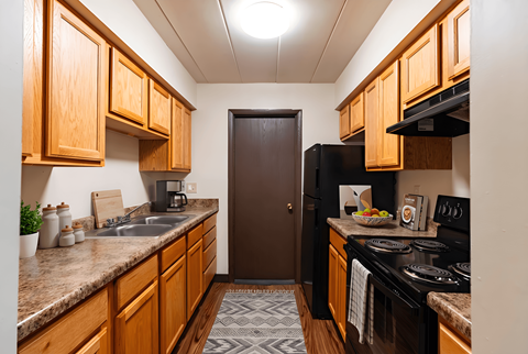 A kitchen with wooden cabinets and a black stove top oven.