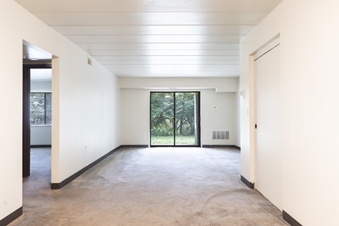 A spacious living room with a large sliding glass doors.