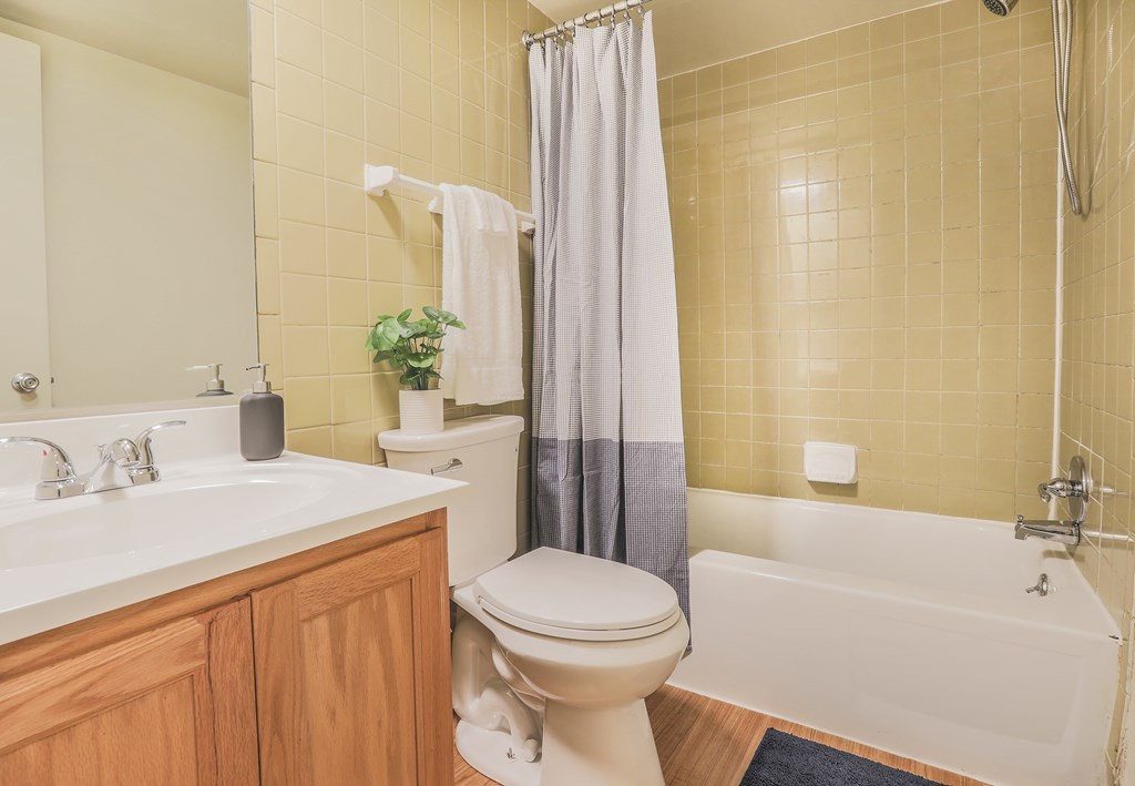 A bathroom with a toilet, sink, and bathtub.