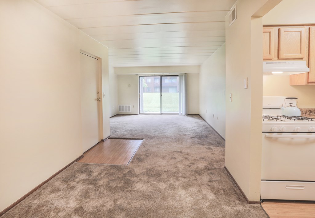 A kitchen area with a refrigerator, sink, and a window.