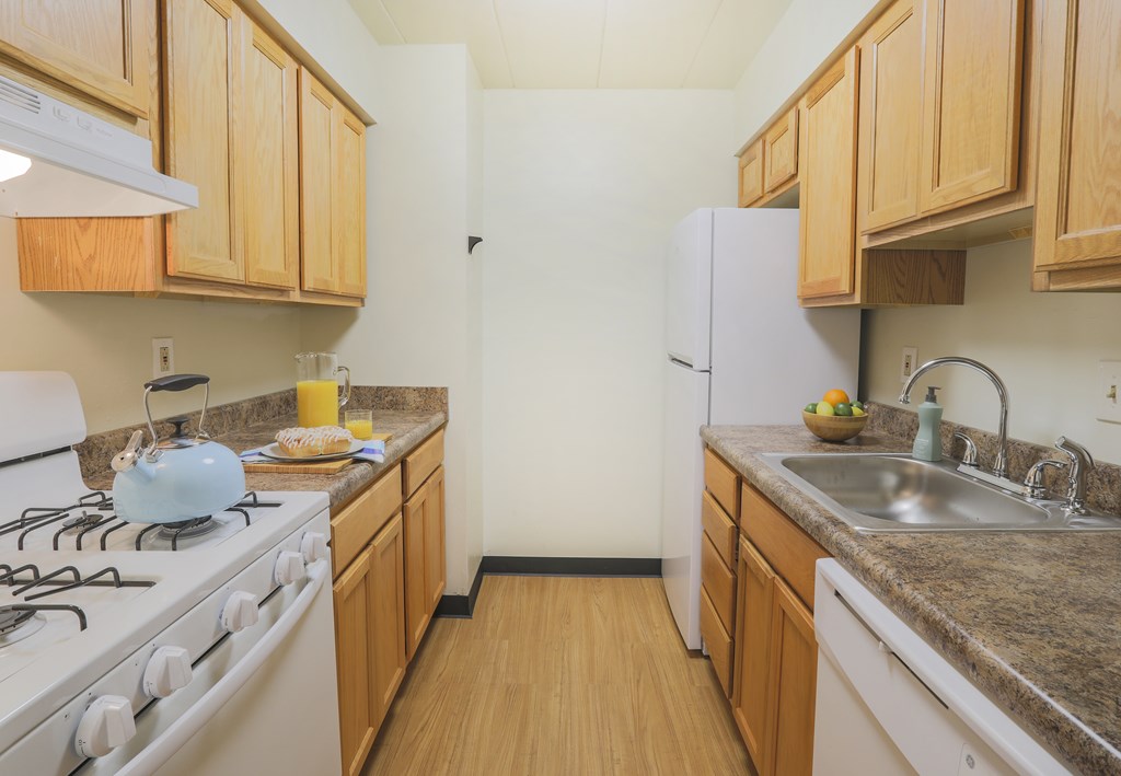 A kitchen with a white stove and wooden cabinets.