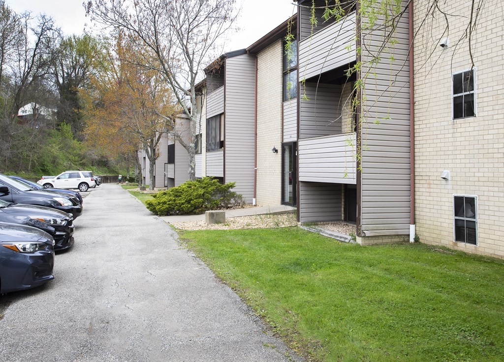 A parking lot with cars and apartment buildings.