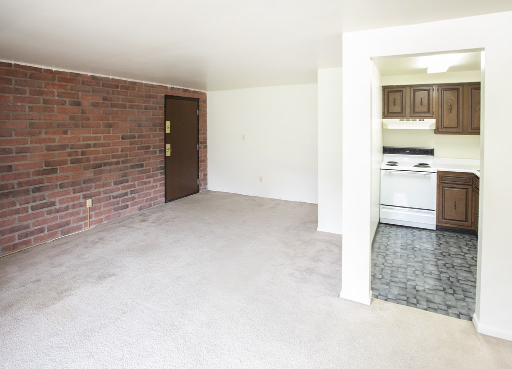 A room with a brick wall and a door.