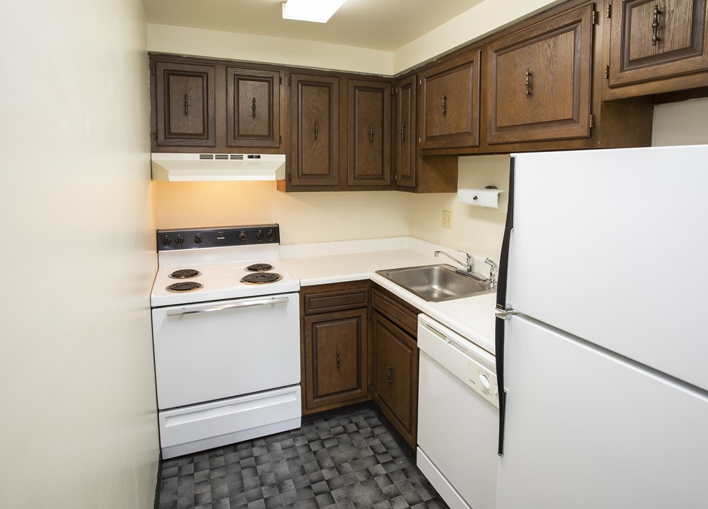A kitchen with a white fridge, white oven and black stove top.