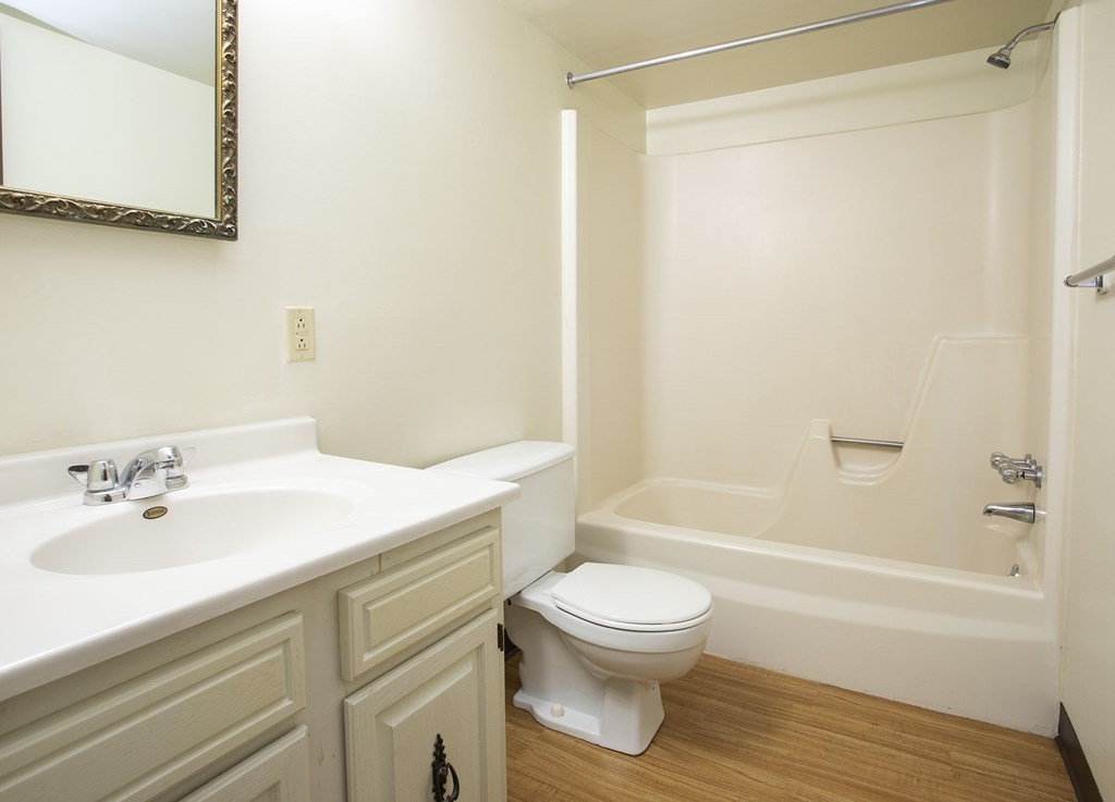 A white bathroom with a sink, toilet and bathtub.