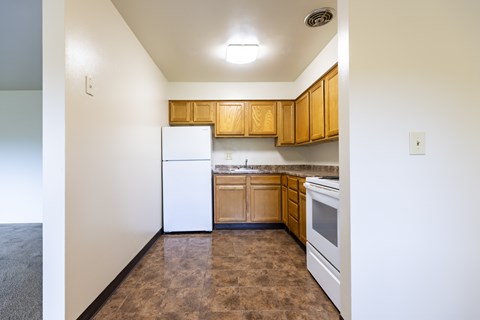 A kitchen with brown cabinets and white appliances.