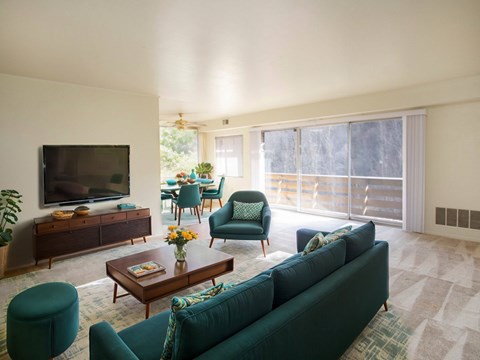 A living room with a green couch and a wooden coffee table.