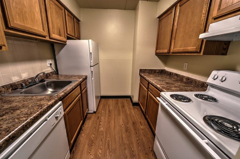 A kitchen with white appliances and wooden cabinets.