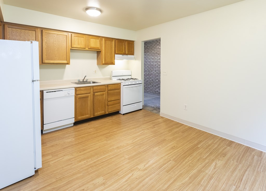 A kitchen with wooden cabinets and white appliances.