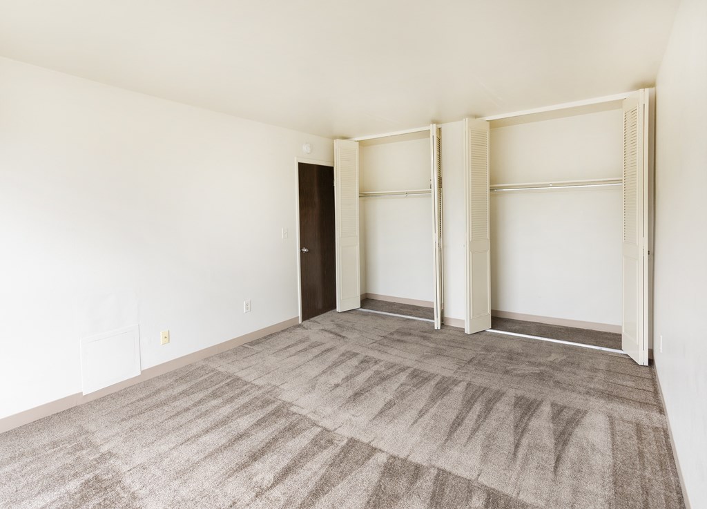 A room with a carpeted floor and a sliding door.