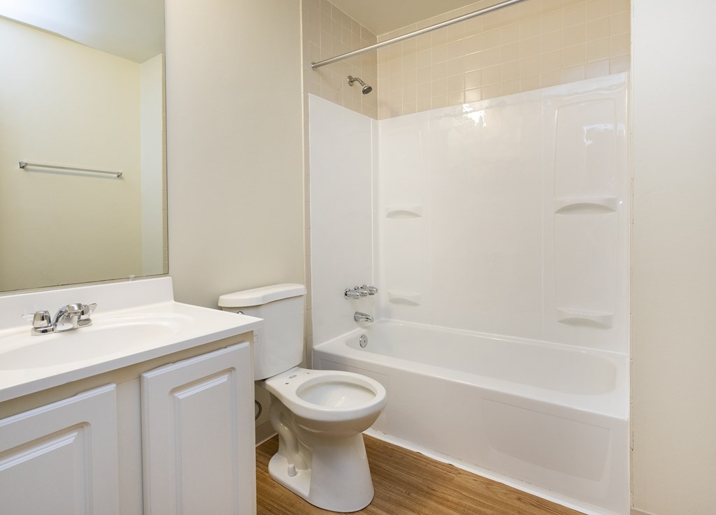 A white bathroom with a toilet, sink, and bathtub.