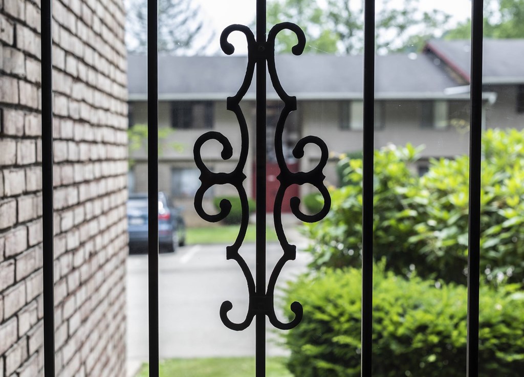 A black wrought iron gate with a decorative design is in the foreground.