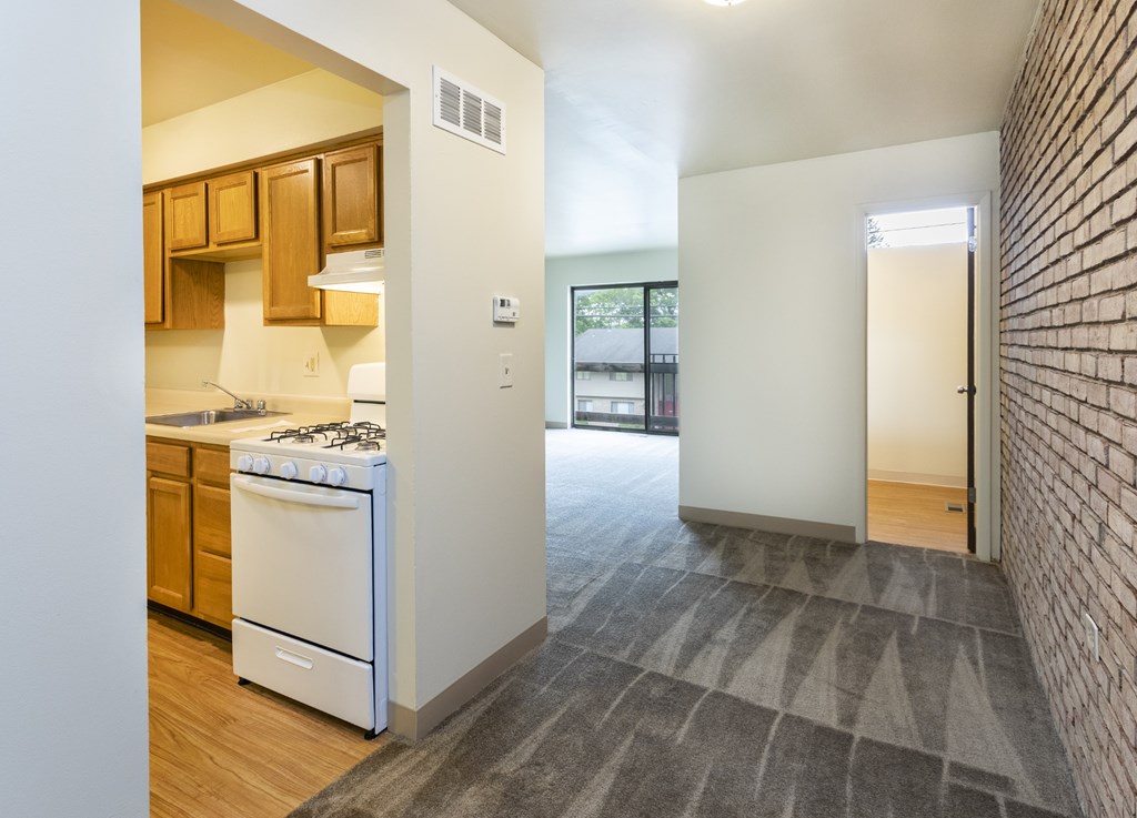 A kitchen with a white stove and wooden cabinets.