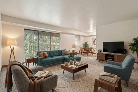 A living room with a couch, chairs, and a television.