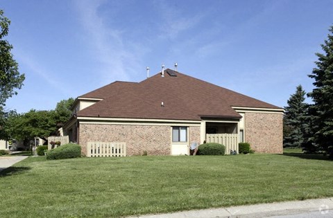 A house with a brown roof and a white fence.