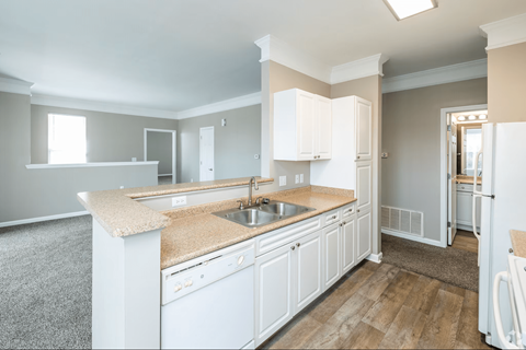 A kitchen with white cabinets and a granite countertop.