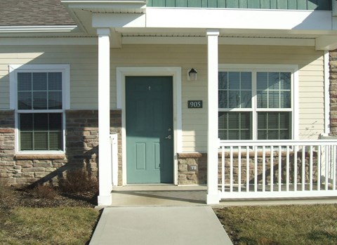 A house with a green door and a white porch.