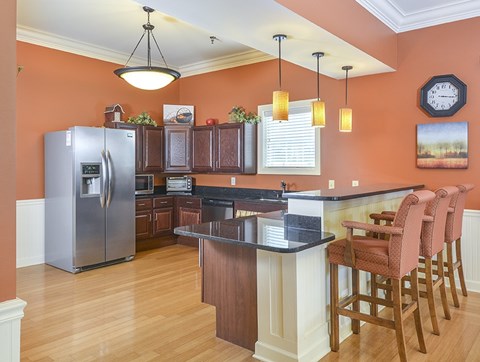 A kitchen with a black counter top and wooden cabinets.