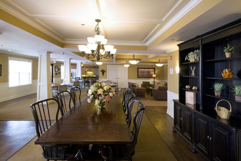 A dining room with a long table set for a meal.