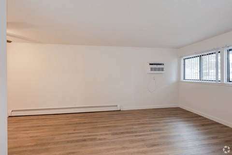 Empty room with wooden floor and white walls.