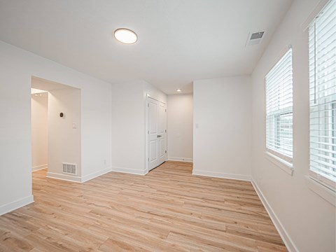 A room with wooden flooring and white walls.