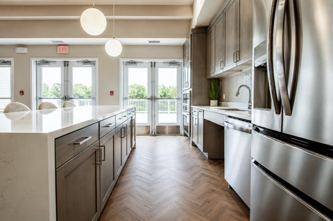 A modern kitchen with stainless steel appliances and wooden floors.