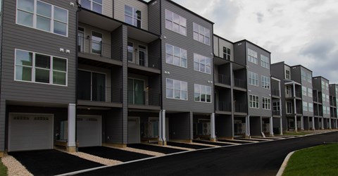 A row of modern apartment buildings with garages.